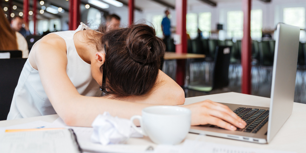 Woman at desk showing fatigue and burnout